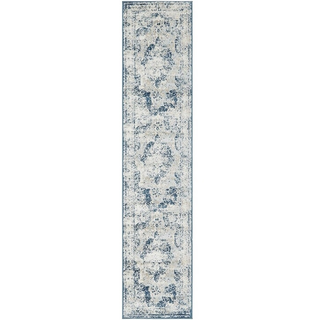 vintage blue rectangular runner rug down an aisle with chairs and people on either side and a man and woman headed towards the runner. It is outdoors. 