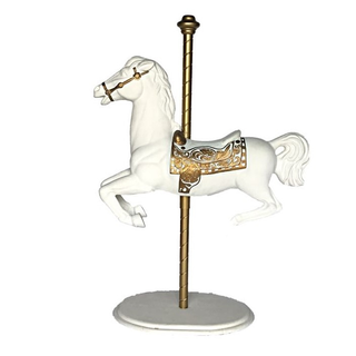 White and gold vintage carousel horse indoors on wood flooring near white fur rug near a black patterned rug. Near the horse is a pile of blue grey briefcases and a large whitewash divider with a lettered sign hanging on it with a clear balloon and mirror