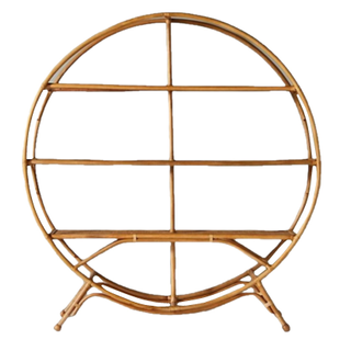 Boho rattan circle shelf indoors with a floral arrangement decorating one corner. On each row in the shelf there are paper place cards. 