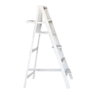 White distressed wood ladder decorated with floral grass decor outdoors