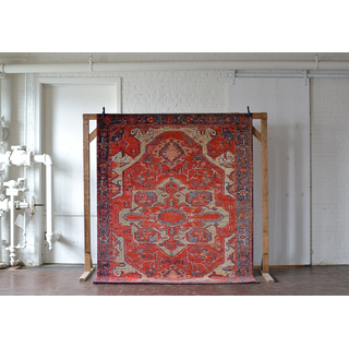 Oversized rug featuring an intricate pattern with bright red hues