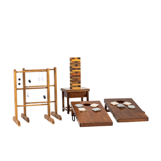 collection of lawn games including a pair of wooden corn hole boards, large wooden jenga set, and a ladder ball set