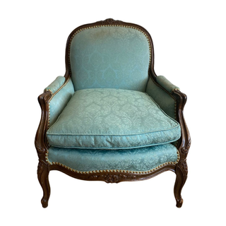 Blue chair with pattern and dark wood detailing 