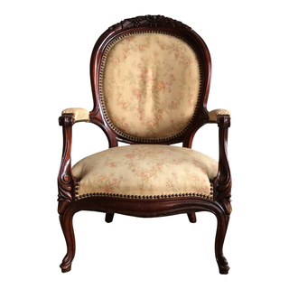 cream floral print upholstered armchair with wood carved details.