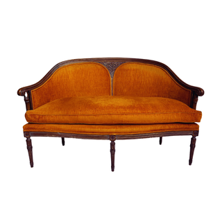 Bright orange settee with curved dark wood detailing for rent from Relics Rentals in Milwaukee