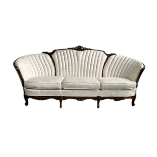 Cream tufted sofa with dark wood accents perfect for a lounge at any party or event