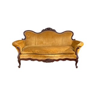 Bright yellow settee with curved arms and mahogany wood carved details