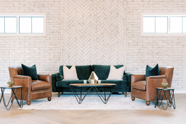 Green sofa, two leather chairs, black and wood tables 