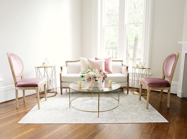 Linen sofa with two pink chairs and gold coffee and side tables 