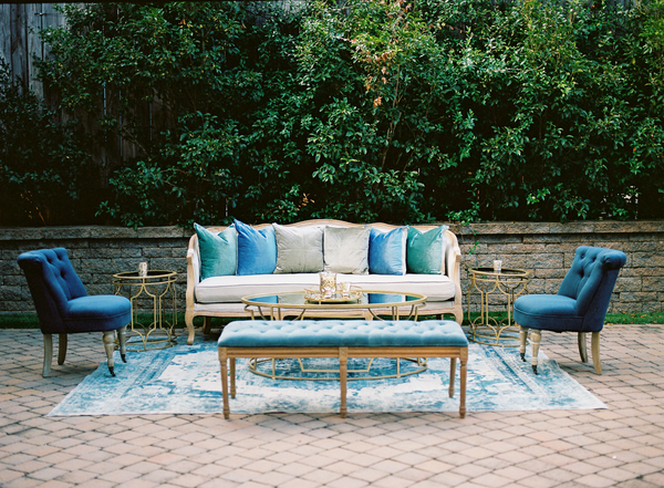 linen sofa with blue chairs and bench in front of stone wall at The Cookery Durham
