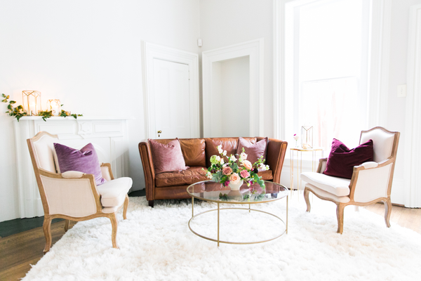 Leather sofa with two linen chairs on fluffy white carpet 