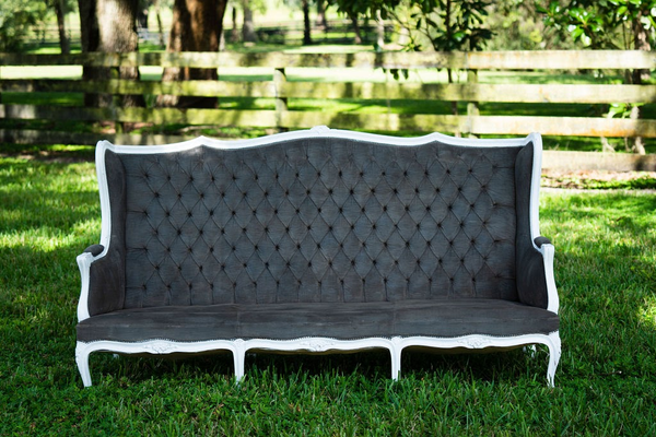 Grey tuffed vintage loveseat with high back and white trim