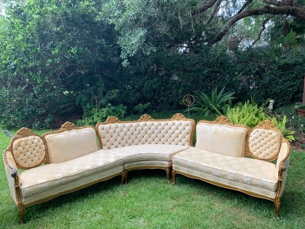 Ivory sectional with tuffed back and gold trim