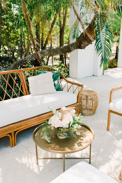 Boho linen rattan ivory beige sofa with boho rattan side tables and a bronze gold coffee table. 