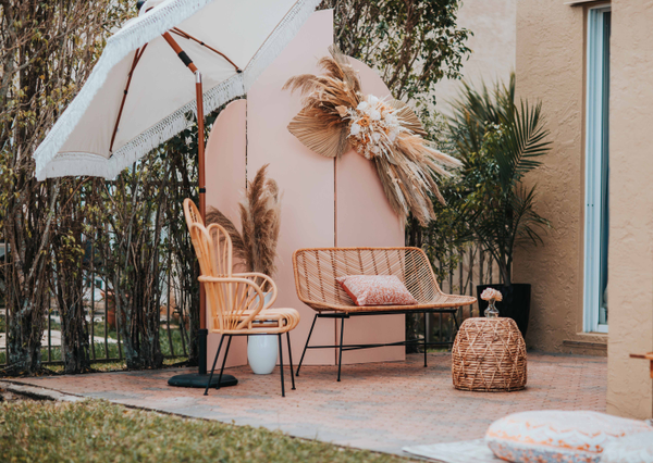 Boho rattan ivory beige loveseat with metal legs lounge with a boho rattan chairs and a boho rattan coffee table. 