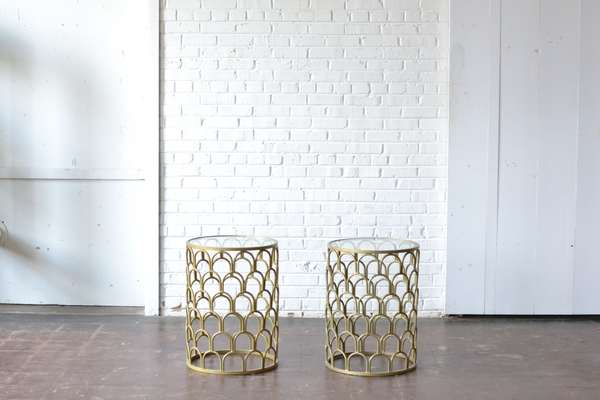 Two round modern gold scalloped end tables with glass tops