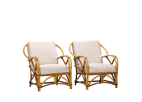 pair of bamboo armchairs with neutral cushions 