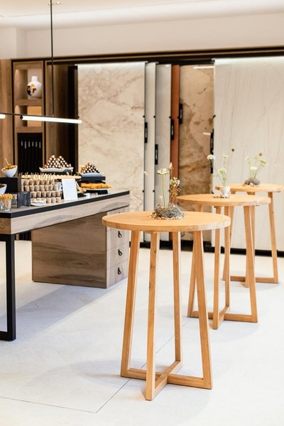 trio of light wood contemporary cocktail tables at event