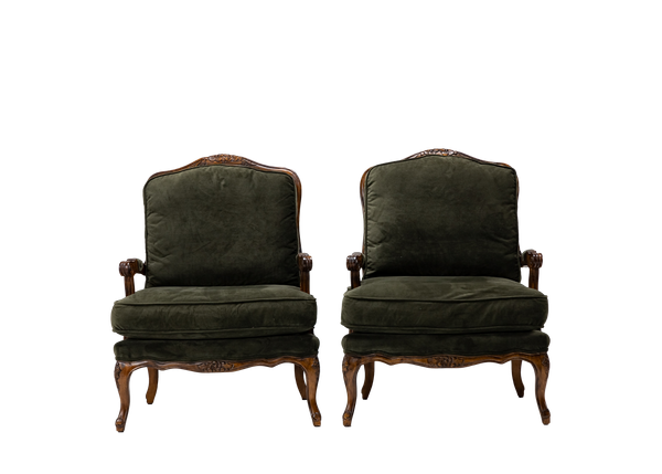 pair of dark olive green velvet armchairs with wooden trim and legs