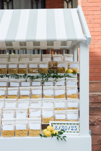 white shelf rental with white and green striped awning displaying wedding favors