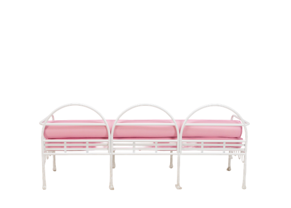 back view of unique white curved metal sofa rental with pink cushions