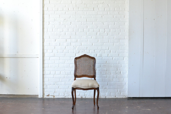 caned wooden side chair with neutral upholstery