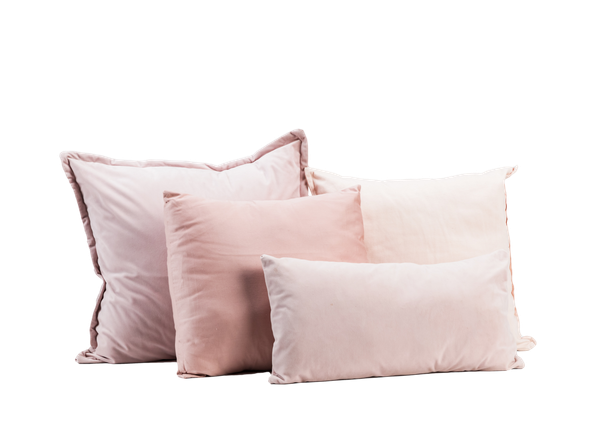 four blush pink pillows in varying sizes 