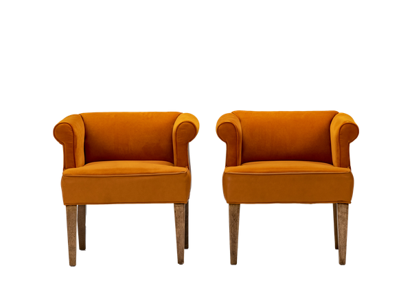 pair of orange velvet and leather chairs with wood legs