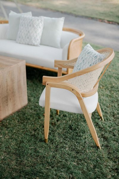 caned back light wood chair rental at event with neutral upholstered seat