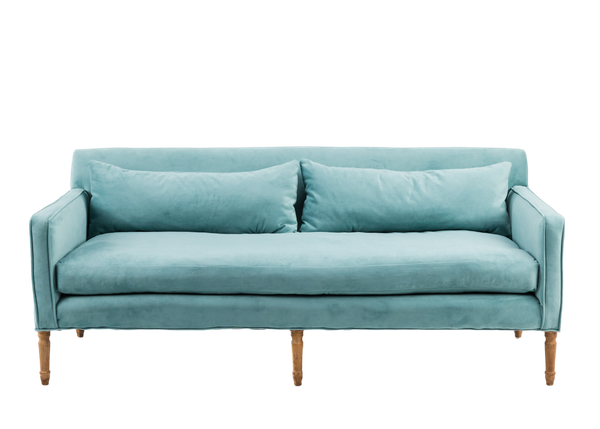 A dusty blue velvet sofa with carbed wood legs.