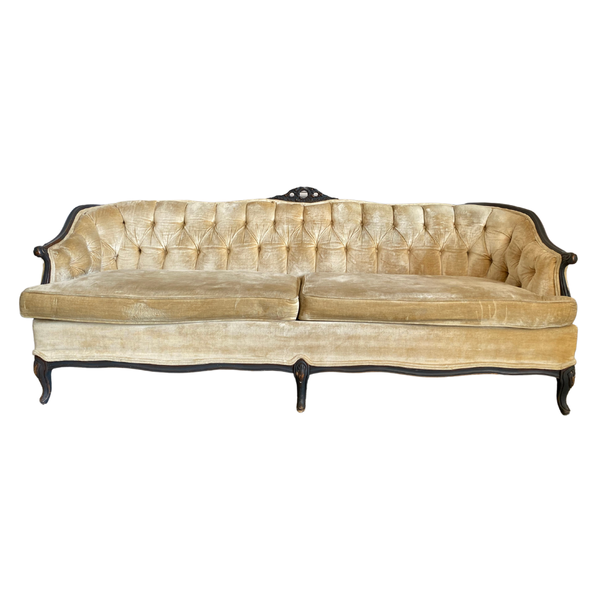 Vintage cream colored velvet upholstered sofa with tufted details and dark brown wood accents