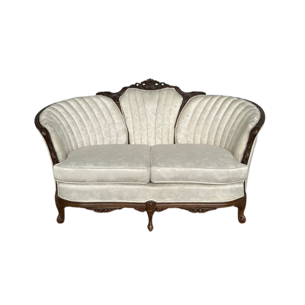 Cream tufted settee with dark brown victorian wood accents