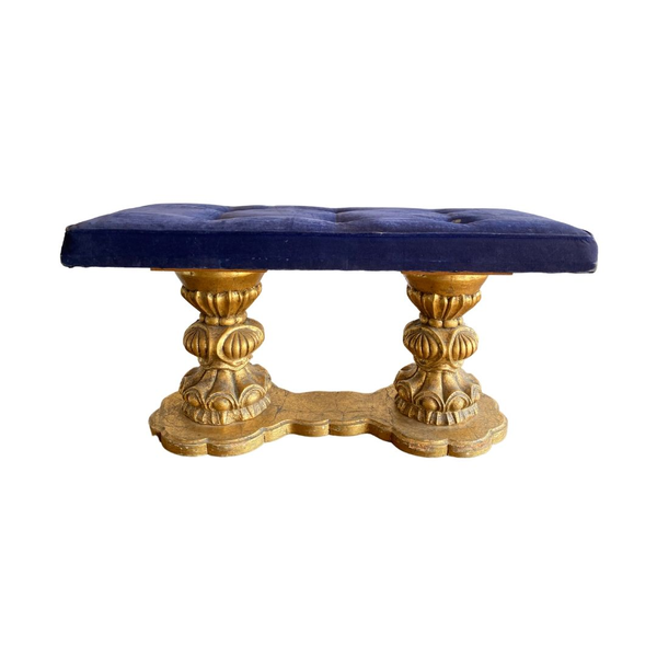 Extravagent and ornate gold base ottoman with a deep blue tufted seat