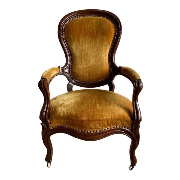 Mustard yellow armchair with curving lines and dark wood accents 