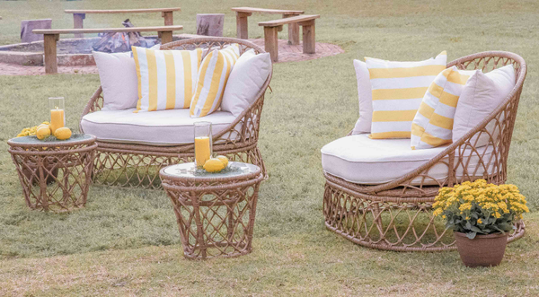 Boho seating lounge with yellow striped pillows and lemons on table by fire at The Space at Feather Oaks wedding.