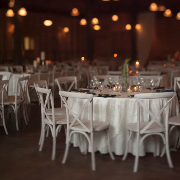 White cross back farm chairs set up for wedding reception inside Carriage House at Goodwood in Tallahassee.