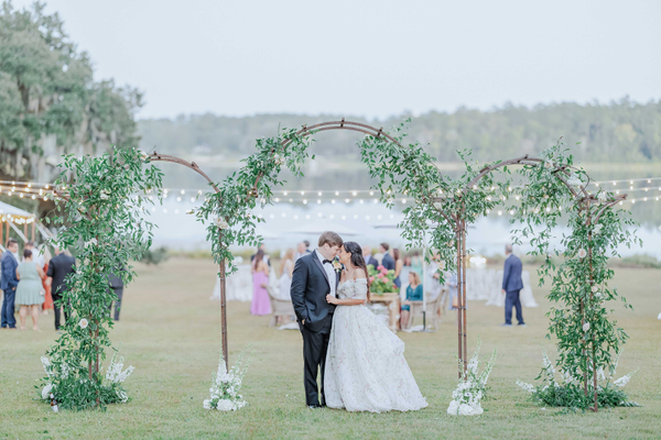 Metal arch with greenery and flowers outside wedding reception at Maclay Gardens.