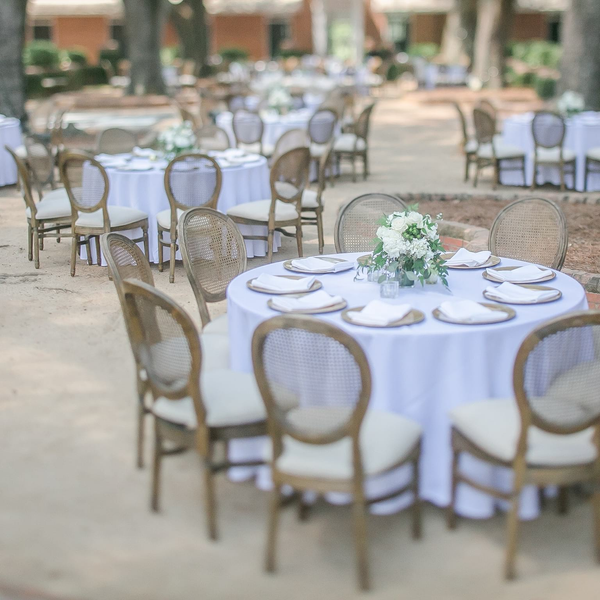 French Cane Back chairs around tables at Courtyard Stables wedding at Pebble Hill Plantation.