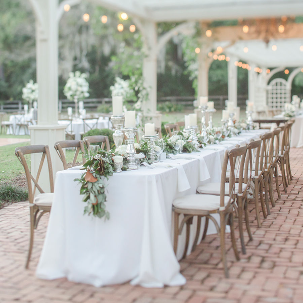 Cross back farm chairs under pergola patio with table garland at The Space at Feathe Oaks.