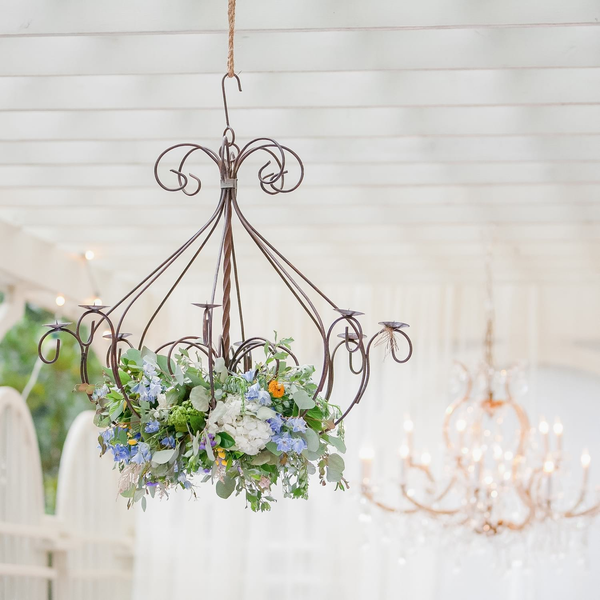 Metal iron chandelier filled with flowers hanging in arbor at The Space at Feather Oaks.