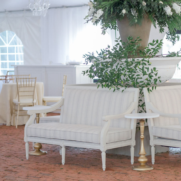 French loveseat with subtle stripes.  Brick floor and smilax for wedding greenery.