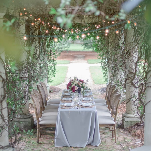 French Cane Back wedding chairs under pergola with grey linens at Pebble Hill Plantation.
