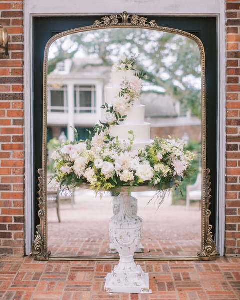 French pedestal table with wedding cake in front of large Primrose mirror.  Photo by Jenna Lindsey.