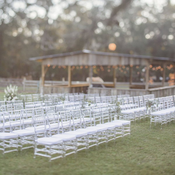 Clear acrylic Chiavari wedding chairs set up for ceremony at The Space at Feather Oaks.