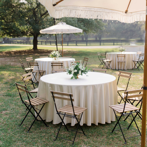 Garden chairs for wedding cocktail hour with patio umbrellas at Pebble Hill Plantation.