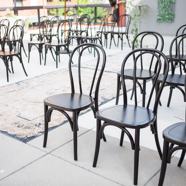 Black bentwood boho chairs at rooftop wedding with rugs at Madison Social in Tallahassee, FL.