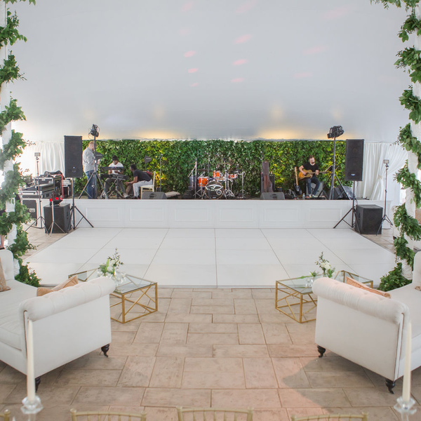 White stage fronts in front of green floor with a white dance floor.