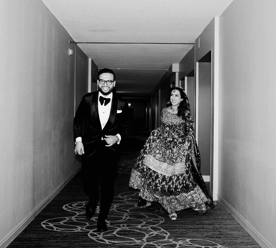 Zaki and his wife running through a hallway during their wedding photoshoot