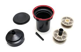 A disassembled development tank showing its lid, funnel, spindle and reels