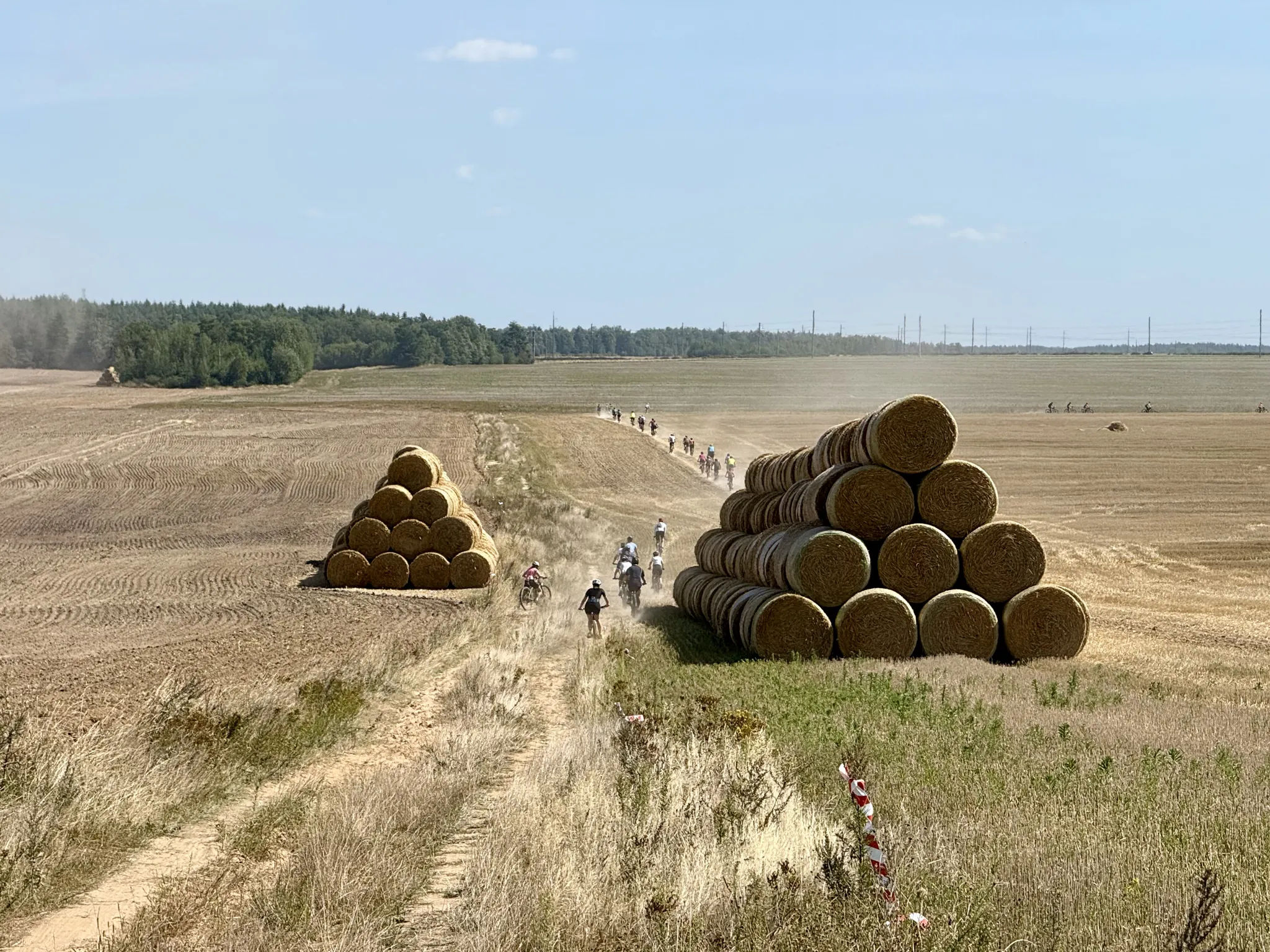 Велосипедисты между стогов соломы